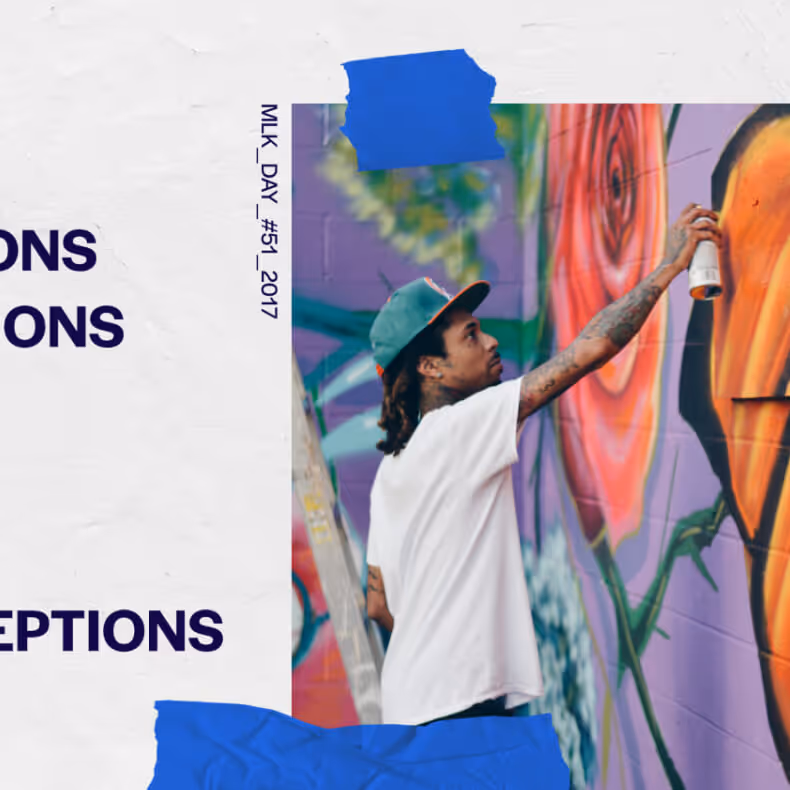 Artist in white t-shirt and green cap spray-painting a colorful mural with roses on a wall.